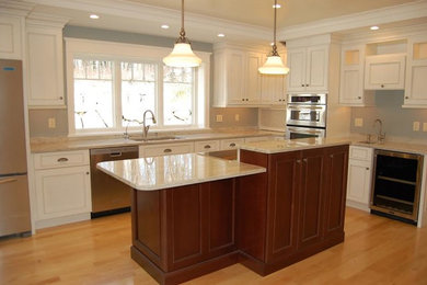 Example of a mid-sized trendy l-shaped light wood floor and beige floor kitchen design in Boston with a double-bowl sink, beaded inset cabinets, white cabinets, quartz countertops, stainless steel appliances and an island