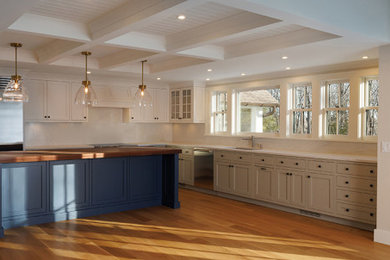 Large transitional l-shaped light wood floor and coffered ceiling eat-in kitchen photo in Bridgeport with an undermount sink, beaded inset cabinets, white cabinets, marble countertops, white backsplash, marble backsplash, stainless steel appliances, an island and white countertops