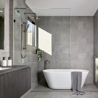 Immagine di una stanza da bagno padronale minimalista con ante lisce, ante grigie, vasca freestanding, piastrelle grigie, lavabo sottopiano, pavimento grigio e top grigio