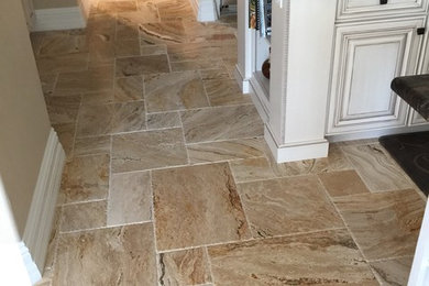 Photo of a small transitional hallway with beige walls, travertine floors and beige floor.