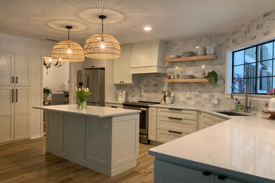 Design ideas for a large traditional l-shaped open plan kitchen in Jacksonville with an undermount sink, shaker cabinets, white cabinets, quartzite benchtops, white splashback, glass tile splashback, stainless steel appliances, medium hardwood floors, with island, beige floor and white benchtop.