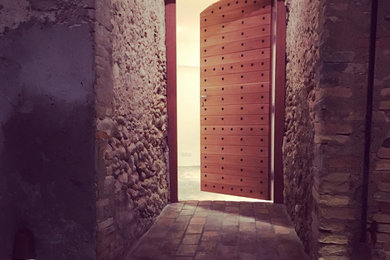 Cette photo montre une porte d'entrée de taille moyenne avec un mur beige, tomettes au sol, une porte simple, une porte en bois foncé, un sol beige et un plafond en bois.