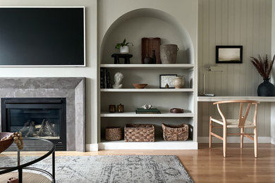 Inspiration for a mid-sized transitional open concept light wood floor, shiplap ceiling and wall paneling living room remodel in Toronto with gray walls, a standard fireplace, a plaster fireplace and a wall-mounted tv
