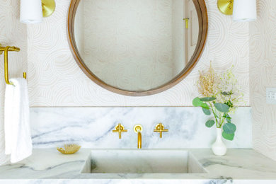 Small transitional dark wood floor and brown floor bathroom photo in Chicago with open cabinets, white cabinets, a two-piece toilet, multicolored walls, an integrated sink, marble countertops and white countertops