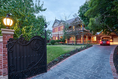 Design ideas for a large traditional two-storey brick red house exterior in Melbourne with a gable roof and a tile roof.