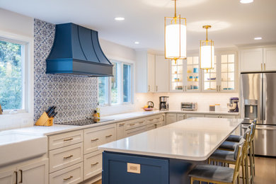This is an example of a large beach style l-shaped eat-in kitchen in Baltimore with an undermount sink, shaker cabinets, blue cabinets, quartz benchtops, multi-coloured splashback, porcelain splashback, stainless steel appliances, medium hardwood floors, with island, brown floor and white benchtop.