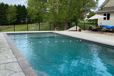 Идея дизайна: прямоугольный бассейн среднего размера на заднем дворе в стиле модернизм с покрытием из бетонных плит