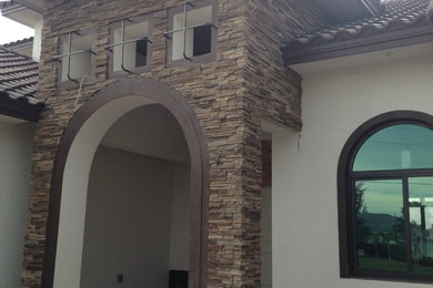 Example of a tuscan white two-story stone exterior home design in Miami with a hip roof