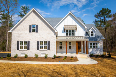 Example of a country white two-story brick and board and batten exterior home design in Richmond with a mixed material roof and a gray roof