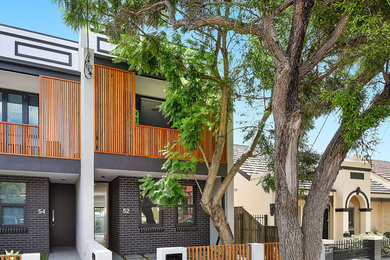 Inspiration for a contemporary two-storey brown townhouse exterior in Sydney with mixed siding.