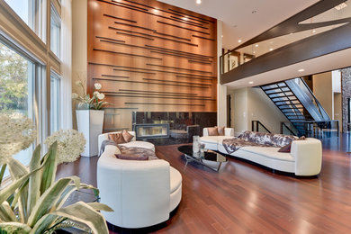 Example of a huge trendy enclosed dark wood floor and brown floor living room design in Calgary with beige walls, a ribbon fireplace and a tile fireplace