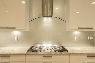 Kitchen - small contemporary galley dark wood floor kitchen idea in DC Metro with an undermount sink, flat-panel cabinets, white cabinets, quartz countertops, metallic backsplash, glass sheet backsplash and stainless steel appliances