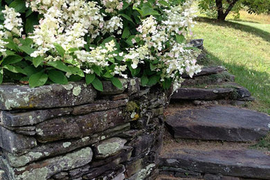 Design ideas for a large traditional backyard retaining wall landscape in Burlington.