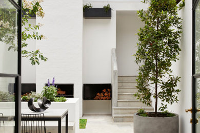 Design ideas for a small transitional courtyard patio with natural stone pavers.