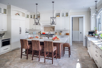 Inspiration for a large timeless l-shaped porcelain tile eat-in kitchen remodel in New York with a farmhouse sink, raised-panel cabinets, white cabinets, quartzite countertops, white backsplash, subway tile backsplash, paneled appliances and an island