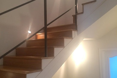 Ejemplo de escalera en U actual grande con escalones de madera y contrahuellas de madera