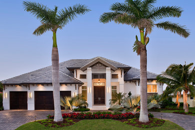 Design ideas for a transitional one-storey stucco white house exterior in Miami with a hip roof and a tile roof.