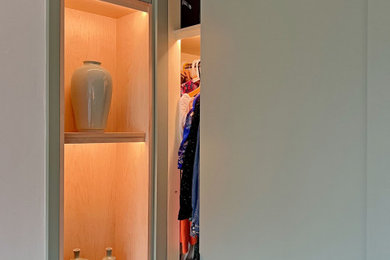 Design ideas for a large contemporary gender neutral dressing room in London with flat-panel cabinets, green cabinets and feature lighting.