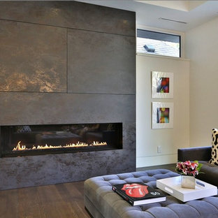 Foto på ett mellanstort funkis allrum med öppen planlösning, med vita väggar, mellanmörkt trägolv, en bred öppen spis, en spiselkrans i trä och en dold TV