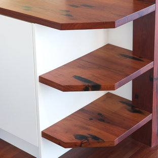 Mid-sized kitchen pantry inspiration - Kitchen pantry - mid-sized u-shaped medium tone wood floor kitchen pantry idea in Newcastle - Maitland with a drop-in sink, wood countertops, black appliances and an island