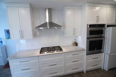 Mid-sized trendy galley ceramic tile and brown floor eat-in kitchen photo in Other with an undermount sink, shaker cabinets, white cabinets, marble countertops, white backsplash, ceramic backsplash, stainless steel appliances and no island