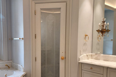 Example of a large classic master marble floor, beige floor, double-sink and coffered ceiling bathroom design in Austin with recessed-panel cabinets, beige cabinets, an undermount tub, a bidet, beige walls, an undermount sink, marble countertops, a hinged shower door, beige countertops and a built-in vanity