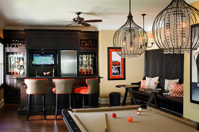 Inspiration for a large timeless dark wood floor and brown floor family room remodel in Atlanta with beige walls and no fireplace