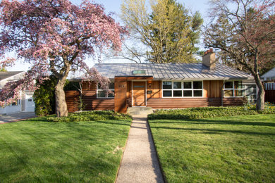 Mid-sized mid-century modern brown one-story metal and board and batten exterior home photo in Philadelphia with a metal roof and a gray roof