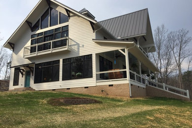 Inspiration for a large farmhouse beige two-story wood house exterior remodel in Atlanta with a shed roof and a metal roof