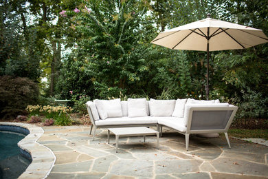 Trendy backyard stone patio photo in DC Metro