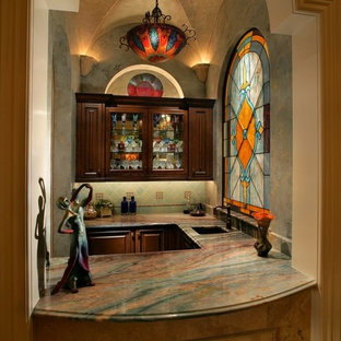 マイアミのヴィクトリアン調のおしゃれなウェットバー (レイズドパネル扉のキャビネット、濃色木目調キャビネット、緑のキッチンパネル) の写真