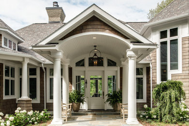 Huge trendy brown two-story wood house exterior photo in Other with a hip roof and a shingle roof