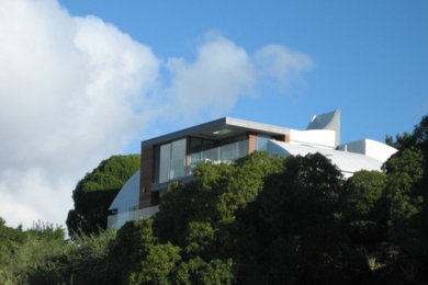 Mid-sized contemporary gray two-story stucco flat roof idea in Christchurch
