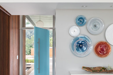Große Retro Haustür mit grauer Wandfarbe, Porzellan-Bodenfliesen, Drehtür, blauer Haustür, grauem Boden und Holzwänden in Sacramento