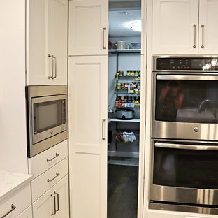 Large transitional kitchen pantry ideas - Example of a large transitional l-shaped medium tone wood floor and brown floor kitchen pantry design in Cedar Rapids with an undermount sink, recessed-panel cabinets, white cabinets, quartzite countertops, gray backsplash, porcelain backsplash, stainless steel appliances, an island and white countertops