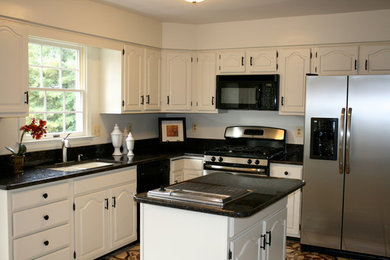 Mid-sized elegant u-shaped dark wood floor and brown floor open concept kitchen photo in Philadelphia with an undermount sink, raised-panel cabinets, white cabinets, granite countertops, stainless steel appliances and an island