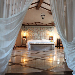 Cette image montre une chambre parentale bohème avec un mur beige, un sol en marbre et un sol multicolore.