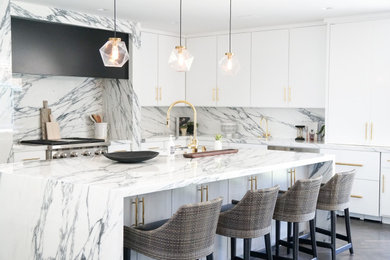 Example of a trendy l-shaped gray floor kitchen design in Los Angeles with flat-panel cabinets, white cabinets, white backsplash, stone slab backsplash, stainless steel appliances, an island and white countertops