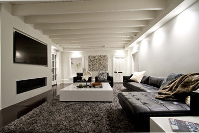 Inspiration for a mid-sized contemporary open concept dark wood floor and brown floor family room remodel in New Orleans with white walls, a ribbon fireplace, a metal fireplace and a media wall