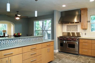 Design ideas for a transitional l-shaped eat-in kitchen in Austin with an undermount sink, flat-panel cabinets, light wood cabinets, quartz benchtops, ceramic splashback and stainless steel appliances.
