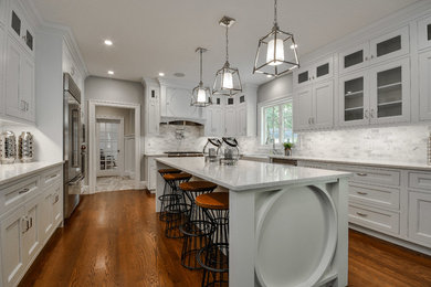 Large transitional u-shaped dark wood floor and brown floor eat-in kitchen photo in Boston with a farmhouse sink, beaded inset cabinets, white cabinets, quartz countertops, white backsplash, marble backsplash, stainless steel appliances and an island