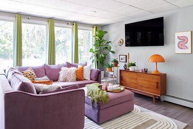 Inredning av ett 60 tals separat vardagsrum, med grå väggar, vinylgolv, en väggmonterad TV och brunt golv