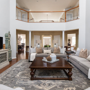 Neutral Two Story Family Room with Tufted Wing Chairs