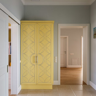 Klassisk inredning av en mellanstor hall, med grå väggar, klinkergolv i porslin och beiget golv