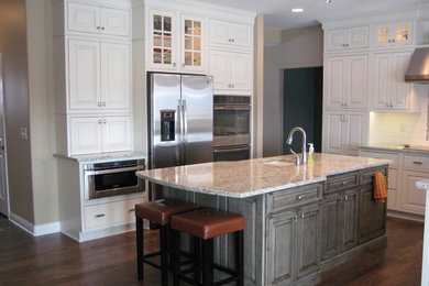 Large traditional u-shaped eat-in kitchen in Minneapolis with an undermount sink, beaded inset cabinets, white cabinets, granite benchtops, white splashback, ceramic splashback, stainless steel appliances, medium hardwood floors and with island.