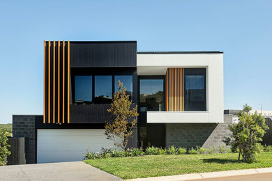 Design ideas for a large contemporary two-storey black house exterior in Geelong with mixed siding, a flat roof, a metal roof and a white roof.
