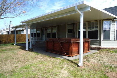 Inspiration for a large modern backyard patio remodel in Other with an awning