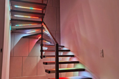 Стильный дизайн: п-образная лестница среднего размера в современном стиле с деревянными ступенями и стеклянными перилами без подступенок - последний тренд
