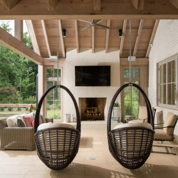 Covered Outdoor Living Porch with Fireplace, Wood Beams & Hanging Chairs