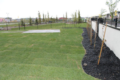 This is an example of a mid-sized full sun backyard landscaping in Calgary for summer.